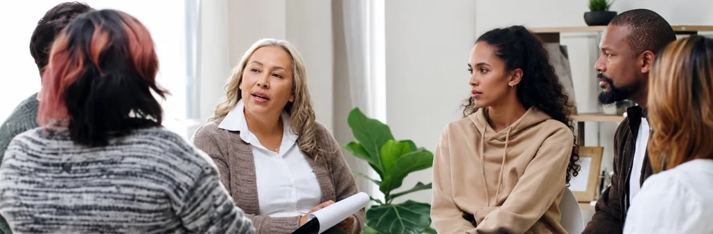 Group Discussion in Therapy Session with Five Adults in Casual Attire