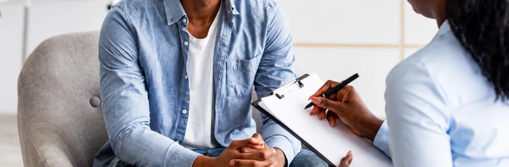 Therapist Taking Notes During Individual Therapy Session With Client